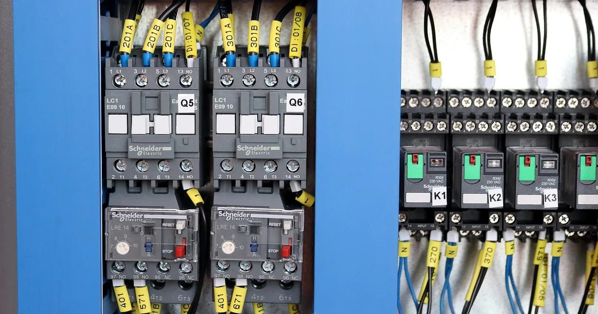 Contatores e relés térmicos identificados dentro de um painel elétrico industrial azul